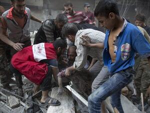 Syrians surround a man as he cries over the body of his child after she was pulled out from the rubble of a budling following government forces air strikes in the rebel held neighbourhood of Al-Shaar in Aleppo on September 27, 2016. (AFP/Karam al-Masri)