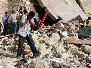 A Syrian man reacts as rescuers look for victims under the rubble of a collapsed building following a reported air strike on the rebel-held neighborhood of Sakhur in Aleppo on July 19, 2016. (AFP/Thaer Mohammed)