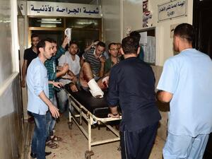 Syrians rush a wounded man into a hospital in the government-controlled side of the northern city of Aleppo following fighting between regime forces and rebels, on October 6, 2016. (AFP/Georges Ourfalian)