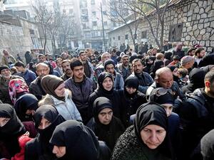 Civilians wait outside a government military police centre to visit relatives, who were evacuated from eastern Aleppo. (AFP/File)