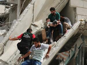 Syrian men remove a baby from the rubble of a destroyed building following a reported air strike in the Qatarji neighborhood of the northern city of Aleppo on September 21, 2016. (AFP/Ameer Alhalbi)
