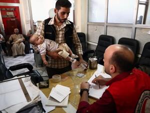 A man registers for vaccine during a vaccination campaign carried out by the Syrian Arab Red Crescent, on September 19, 2016, in the rebel-held town of Douma, on the eastern edges of the capital Damascus. (AFP/Abd Doumany)