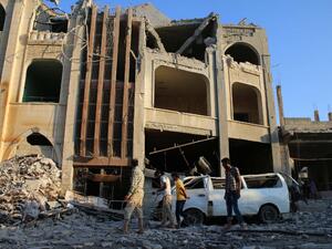 Syrians walk past a makeshift hospital in the area of Jasim in the southern province of Deraa on July 31, 2016, after it was hit in an airstrike that killed at least seven. (AFP/Mohamad Abazeed)