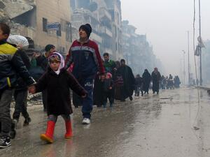Syrian residents, fleeing violence in the restive Bustan al-Qasr neighborhood, arrive in Aleppo's Fardos neighborhood on December 13, 2016. (AFP/Stringer)