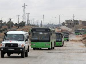 Buses sent to evacuate residents from Fuaa and Kafraya arrive at a rebel-held checkpoint on the outskirts of the two Syrian villages under rebel siege, on December 18, 2016. (AFP/Omar Haj Kadour)