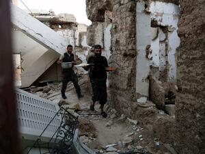 Fighters from the Free Syrian Army carry food as they prepare to break the fast during the month of Ramadan on June 16, 2016 in the rebel-held neighborhood of Jobar, outside the capital Damascus. (AFP/Sameer al-Doumy)