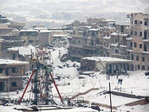 Syrians walk in a snow covered street in the town of Maaret al-Numan, in Syria's northern province of Idlib, on December 22, 2016. (AFP/Ghaith Omran)