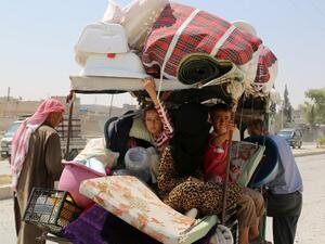Syrian children sit in a cart, loaded with belongings, in the northern Syrian town of Manbij as civilians go back to their homes on August 14, 2016 after the Arab-Kurdish alliance, known as the Syrian Democratic Forces (SDF), pushed Daesh out of the city. (AFP/Delil Souleiman)