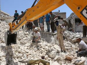 Syrian civil defense workers look for survivors under the rubble of a collapsed building following reported air strikes on July 17, 2016 in the rebel-controlled neighborhood of Karm Homad in the northern city of Aleppo. (AFP/Thaer Mohammed)
