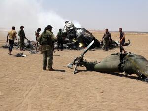A picture taken on August 1, 2016 shows Syrian rebels gathering around the wreckage of a Russian Mi-8 military transport helicopter after it was shot down in Idlib province. (AFP/Mohamed al-Bakour)