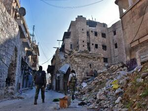 Syrian pro-government forces walks past rubble in old Aleppo's Jdeideh neighborhood on December 9, 2016. (AFP/George Ourfalian)