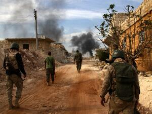 Syrian government forces walk in the strategic area of the Bazo hilltop, north of Khan Tuman on the southern outskirts of the northern embattled Syrian city of Aleppo on October 25, 2016. (AFP/George Ourfalian)