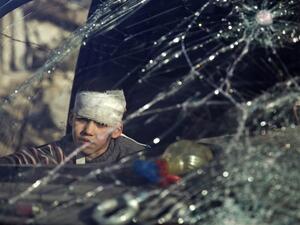 A wounded by sits inside an ambulance as Syrian rebels and their families gather at the rebel-held al-Amiriyah neighborhood of Aleppo as they wait to be evacuated on December 15, 2016. (AFP/Karam al-Masri)