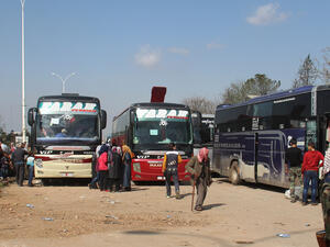 Buses carrying civilians from two government-held villages in Idlib wait in Aleppo, before the explosion. (AFP/Omar Haj Kadour)
