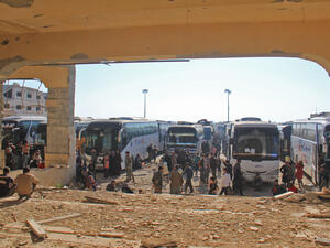 Civilians from besieged government-held villages Fuaa and Kafraya wait to be handed over from opposition to government forces near Aleppo, April 19 2017. (AFP/Omar Haj Kadour)