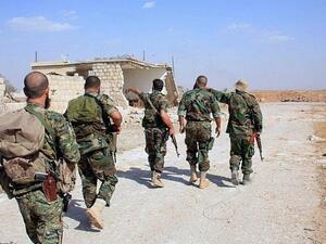Syrian regime soldiers walk down a road in an area around Kweyris military airport, in eastern Aleppo. (AFP/ File Photo)