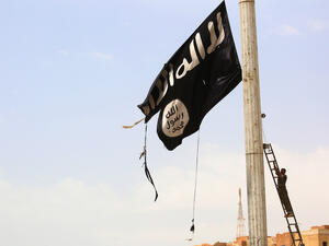 A tattered Daesh flag being removed by a Kurdish fighter in Tabqa, April 30 2017. (AFP/Delil Souleiman)