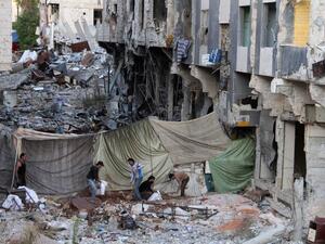 Rebel fighters dig and fill sandbags for barricades behind a sniper curtain to protect them from government forces in the southern Syrian city of Daraa. (AFP)