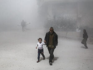 A Syrian man and girl flee following a reported government air strike on the rebel-controlled town of Hamouria. (AFP/ File Photo)