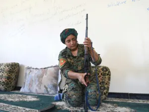 Yazidi fighter Heza prepares her rifle in an abandoned home used as a base on the eastern outskirts of Raqa on July 18, 2017. (AFP)