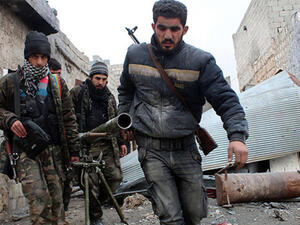 Opposition fighters carrying a rocket launcher during clashes against government forces in the Sheikh Lutfi area, west of the airport in the northern Syrian city of Aleppo (AFP)