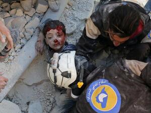The White Helmets, Syrian civil defence volunteers, rescue a boy from the rubble in Aleppo last month. (Ameer Alhalbi / AFP)