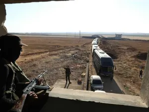 A militant watches as a convoy of buses gets ready to enter the towns of Foua and Kefraya to evacuate their residents on July 18, 2018. (AFP/ File)