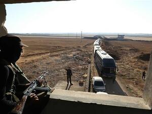 A militant watches as a convoy of buses gets ready to enter the towns of Foua and Kefraya to evacuate their residents on July 18, 2018. (AFP/ File)