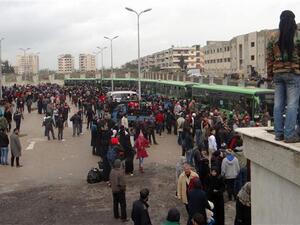 Militants and their families gather as they prepare to board a bus ahead of their evacuation from the al-Waer neighborhood of the Syrian city of Homs, March 18, 2017. (AFP/File)