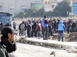 Syrian government forces stand guard as civilians and rebels began evacuating the district of al-Waer in the city of Homs. (AFP/Louai Beshara)