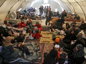 Syrians, who were injured in a suicide car bombing that targeted buses carrying evacuees from besieged government-held towns, sit in a tent on the Syrian-Turkish border in Idlib province on April 17, 2017. (AFP/Omar Haj Kadour)