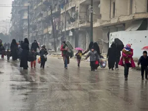 Under the hail of bullets, women and children hurry to leave one of the areas in south Damascus fought over by regimes forces and opposition groups, (AFP/ File Photo) 