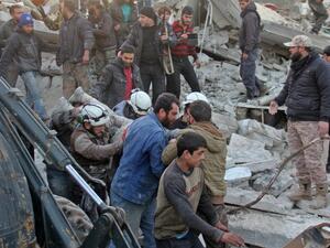 Syrian civil defense volunteers carry a wounded man following a reported airstrike by government forces, in the Syrian town of Binnish, on the outskirts of Idlib, on January 12, 2017. (AFP/Omar Haj Kadour)