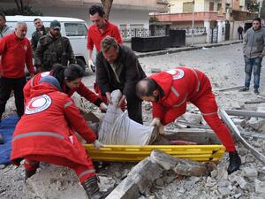 Syrian Red Crescent personnel evacuate the body of a man following a reported mortar strike by rebel fighters in a government-held part of the Syrian city of Homs, on February 10, 2017. (AFP/Stringer)
