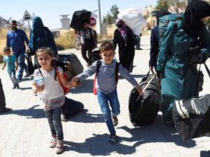 Syrian refugees walk on their way back to the Syrian city of Jarabulus. (AFP/Bülent Kiliç)