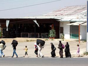 Carrying their luggage people walk close to the area of the Masnaa crossing between the eastern Lebanon and neighboring Syria on 19 July 2012. (AFP/File)