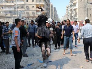 A Syrian civil defense volunteer evacuates a woman following a reported airstrike on April 23, 2016 in Aleppo. (AFP/Ameer Alhalbi)