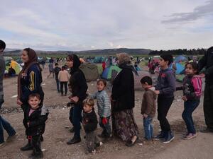 Syrian and Iraqi refugees wait to receive food at the Greek-Macedonian border near the village of Idomeni on February 27 , 2016. (AFP/Louisa Gouliamaki)