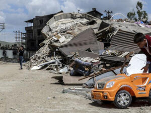 A child plays with a toy car in a street next to damaged buildings after heavy fightings between Turkish government troops and Kurdish fighters after the curfew in the southeastern Turkey Kurdish town of Yuksekova. (AFP/File)