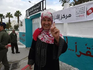 A Tunisian woman voter showcases her ink-stained index finger outside a polling station in Ben Arous near the capital Tunis on May 6, 2018. (AFP/File Photo)