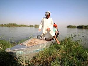 A "Marsh Arab" gets out of a boat in the al-Ahwar Marshlands in Iraq (AFP)