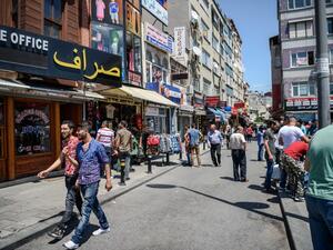 Syrian and Turkish people walk in a street next to shops with Arabic signs on July 4 ,2016 in Fatih neighborhood in Istanbul. (AFP/Ozan Kose)