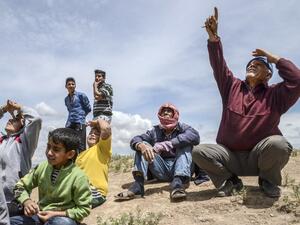 People look on as warplanes carry out bombing nearby in Kilis on May 7, 2016. (AFP/Ilyas Akengin)