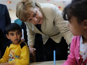 German Chancellor Angela Merkel talks with refugee children at a preschool, during a visit to a refugee camp on April 23, 2016 (AFP/File)