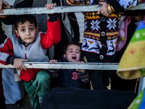 Syrian families at a Turkish border gate near Kilis on February 8, 2016. (AFP/Bulent Kilic)