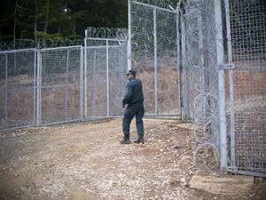 A Bulgarian border police officer stands near a new barbed wire fence at the border between Bulgaria and Turkey near the town of Malko Tarnovo on May 22, 2016. (AFP/Nikolay Doychinov)