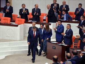 People applaud as Turkey's outgoing Prime Minister Ahmet Davutoglu (C) walks on May 17, 2016 during the discussions on the ruling AK Party's proposal regarding the amendment of the immunity at the Turkish Parliament in Ankara. (AFP/Adem Altan)