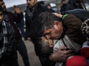 Syrian father Ali embraces one of his children, Zeyn, upon their arrival from the Syrian city of Idlib to the Turkish crossing gate of Cilvegozu in Reyhanli in Hatay near the Syrian border on December 17, 2016. (AFP/Bulent Kilic)