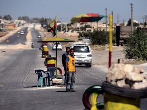 Back in 2012, a Kurdish man guards a checkpoint on the road to the city of Afrin near the Syria-Turkey border (AFP)
