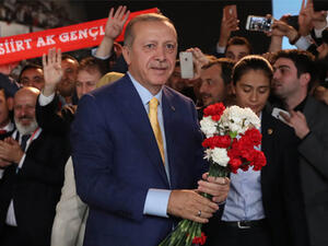 Turkish President Tayyip Erdogan gives flowers to his supporters upon his arrival at the Extraordinary Congress of the ruling AKP (AFP)